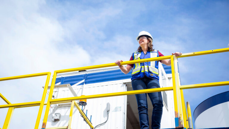 Danielle Smith in a hard hat and safety vest on an industrial work site