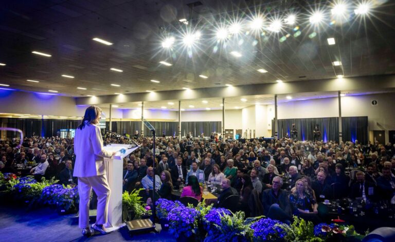 Danielle Smith speaks from the podium to a packed hall