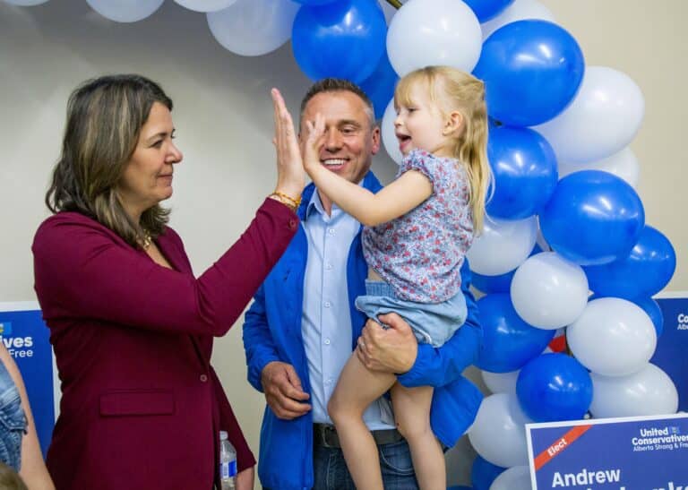Danielle Smith visits with a parent and young child